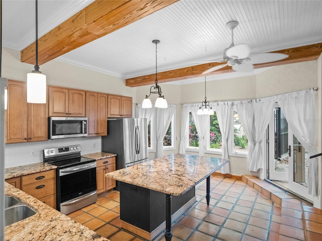 kitchen featuring light stone countertops, a kitchen bar, a kitchen island, ceiling fan with notable chandelier, and appliances with stainless steel finishes