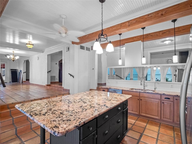 kitchen with a kitchen breakfast bar, ceiling fan with notable chandelier, sink, pendant lighting, and a kitchen island