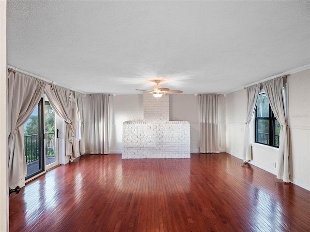 unfurnished living room with a textured ceiling, ceiling fan, and dark hardwood / wood-style floors