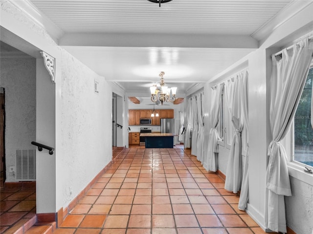 kitchen with stainless steel appliances, an inviting chandelier, pendant lighting, a breakfast bar area, and light tile patterned floors