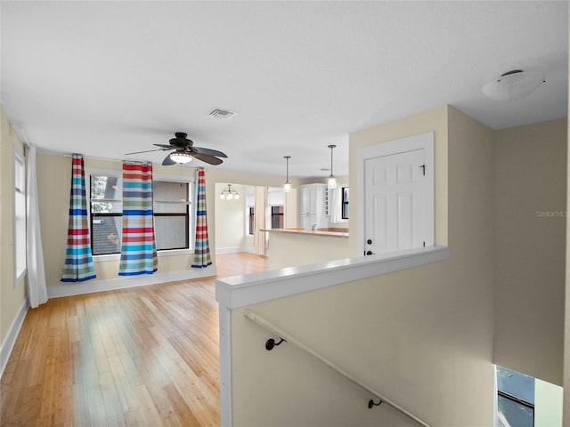 kitchen with ceiling fan, light hardwood / wood-style floors, and decorative light fixtures