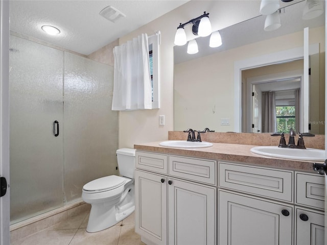 bathroom with vanity, a shower with door, tile patterned floors, toilet, and a textured ceiling