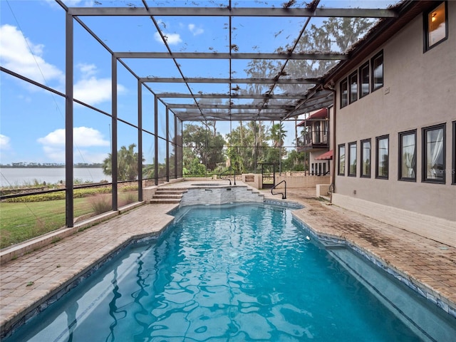 view of pool with an in ground hot tub, a patio, a water view, and glass enclosure