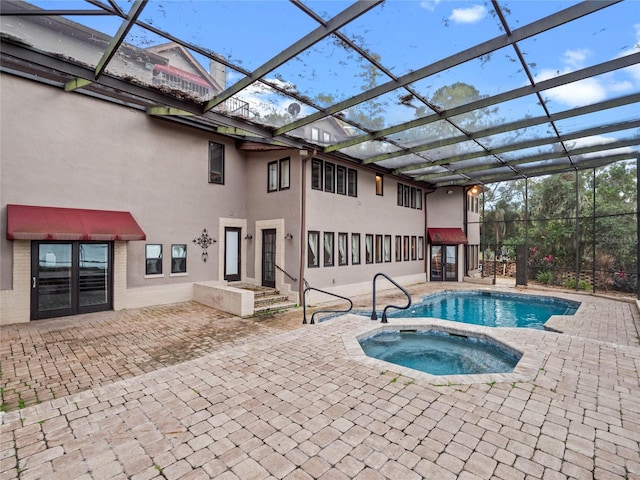 view of pool featuring glass enclosure and an in ground hot tub