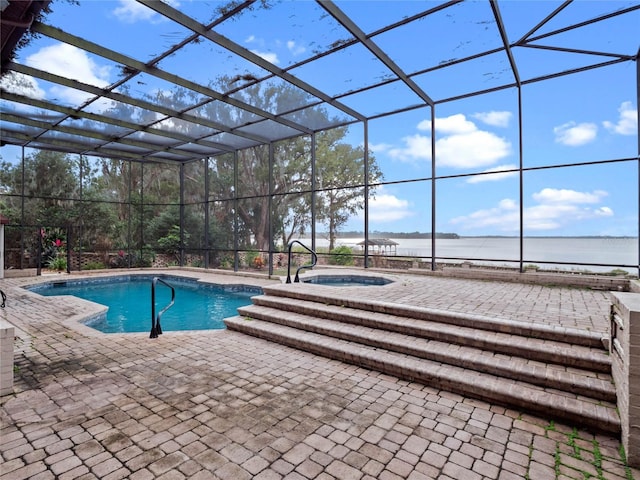 view of swimming pool with an in ground hot tub, a water view, glass enclosure, and a patio area