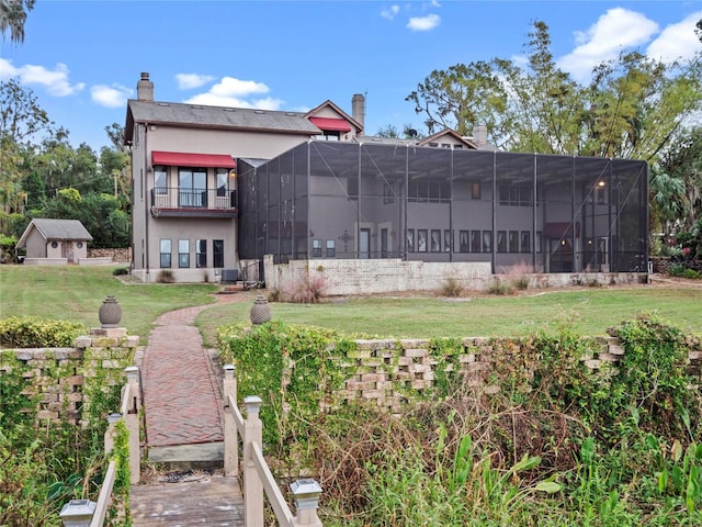 rear view of house featuring a lanai, central air condition unit, a lawn, and a balcony