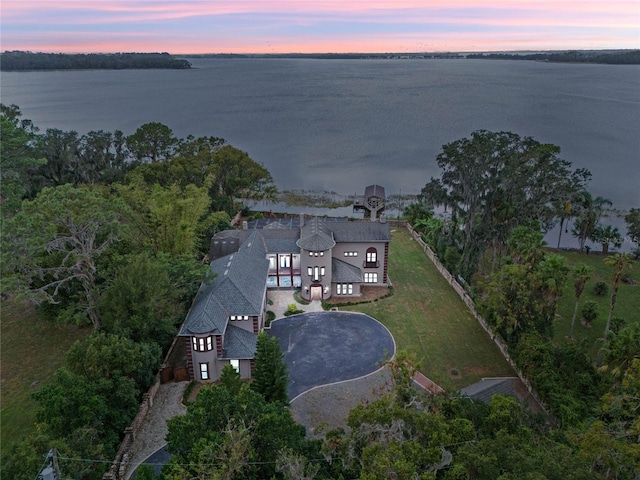 aerial view at dusk featuring a water view