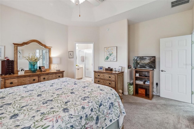 bedroom featuring light colored carpet, ceiling fan, and connected bathroom