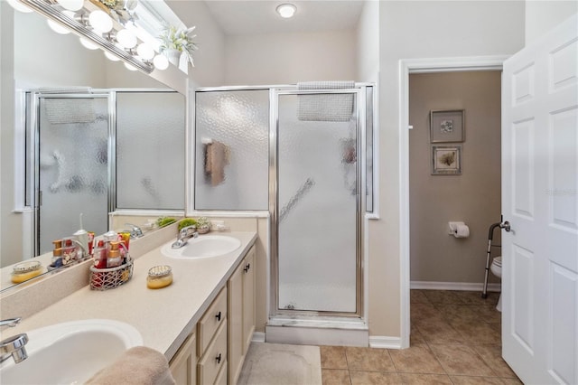 bathroom with toilet, vanity, tile patterned floors, and a shower with door