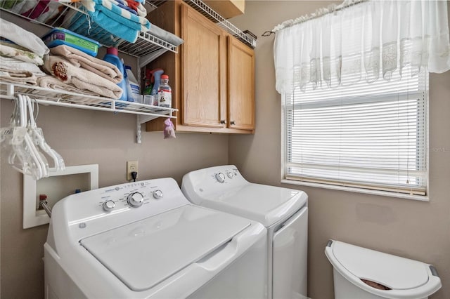 washroom with separate washer and dryer and cabinets