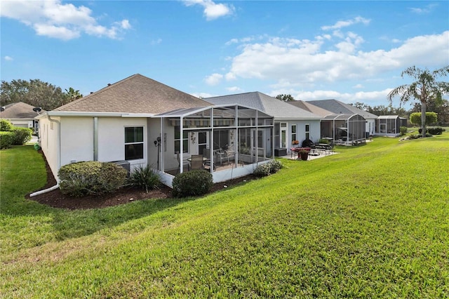 back of house with a patio area, a yard, and a lanai