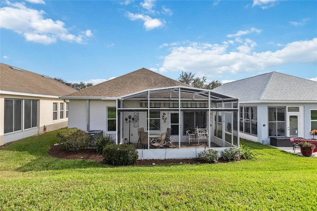 back of property featuring glass enclosure and a lawn