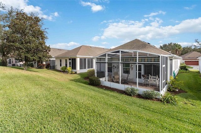 back of property featuring glass enclosure and a yard