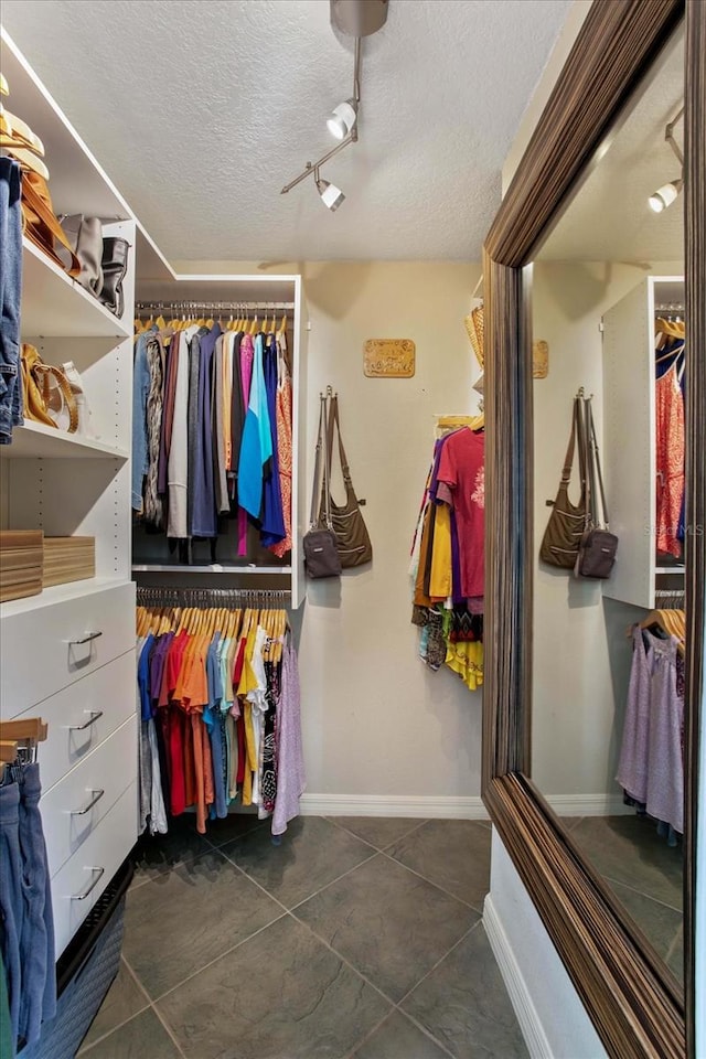 walk in closet featuring dark tile patterned floors