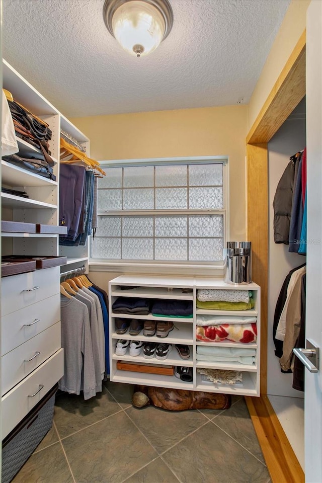 walk in closet featuring dark tile patterned floors