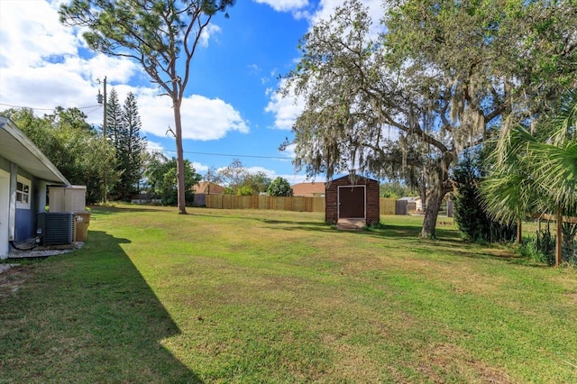 view of yard with central AC and a storage unit