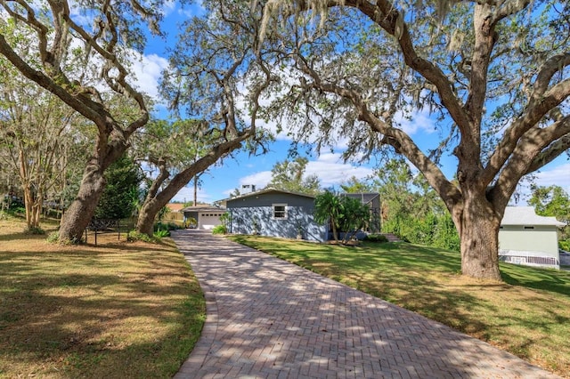 single story home featuring a garage, a front lawn, and a lanai