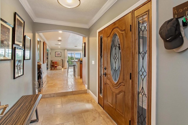 foyer entrance featuring a textured ceiling and crown molding