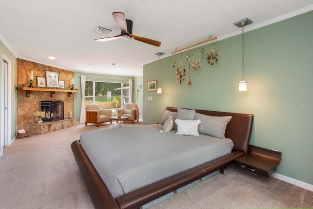 carpeted bedroom featuring a stone fireplace, ceiling fan, and crown molding