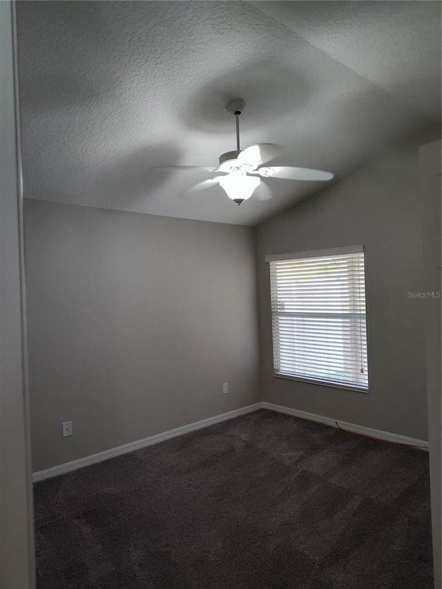 carpeted empty room with a textured ceiling, ceiling fan, and lofted ceiling