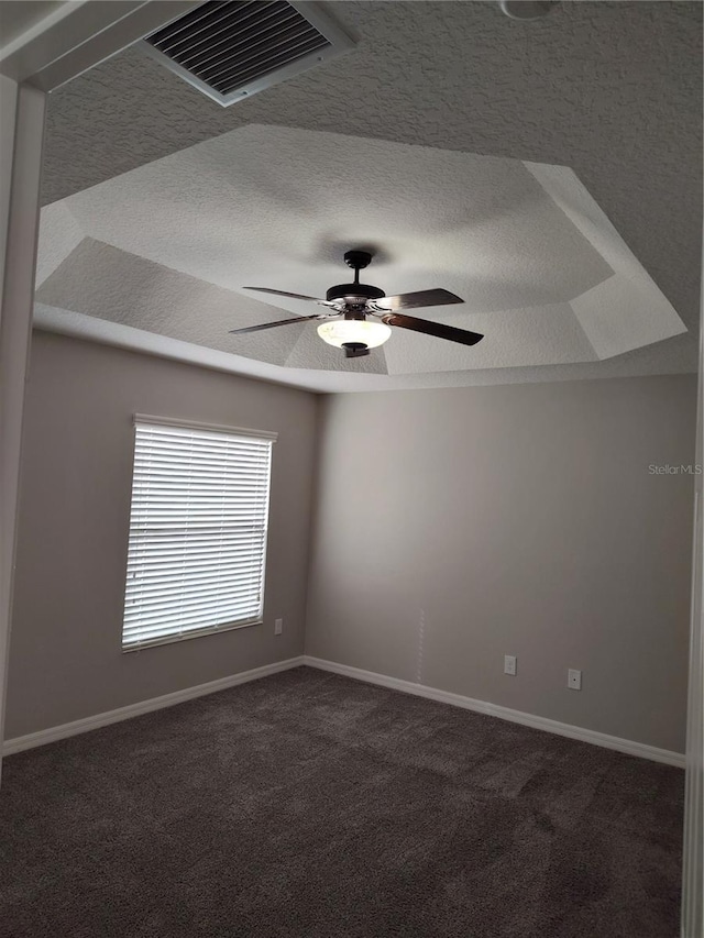 spare room with dark colored carpet and ceiling fan