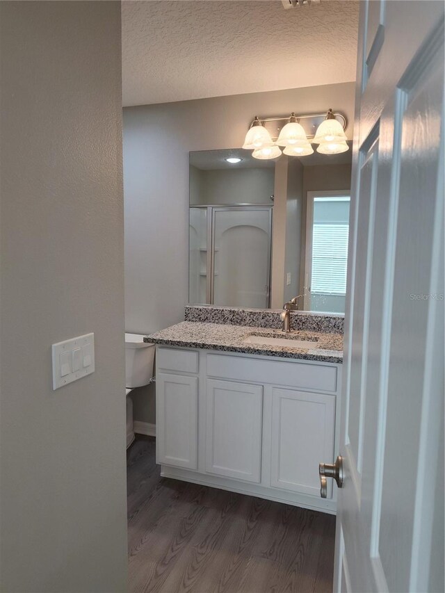 928 Nuthatch Ave, The Villages, FL 32163 - bathroom featuring wood finished floors, vanity, a shower with shower door, and toilet