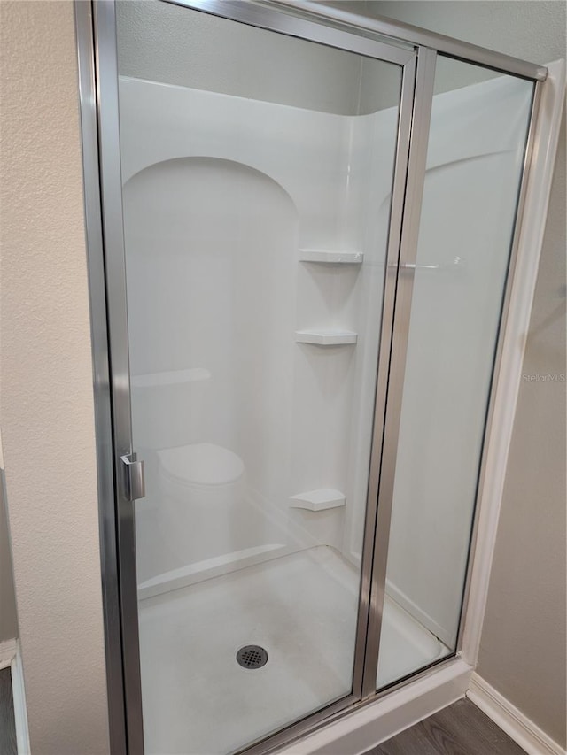 bathroom featuring hardwood / wood-style floors and an enclosed shower