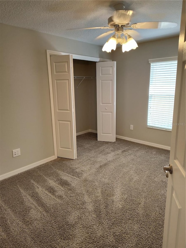 unfurnished bedroom with carpet, ceiling fan, a textured ceiling, and a closet