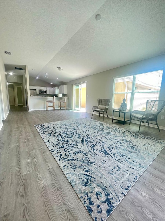 928 Nuthatch Ave, The Villages, FL 32163 - living area featuring light wood-type flooring, baseboards, and a textured ceiling