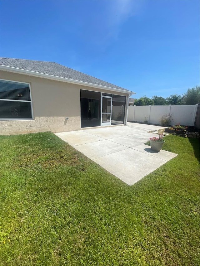 928 Nuthatch Ave, The Villages, FL 32163 - rear view of house featuring a patio, stucco siding, a sunroom, and roof with shingles