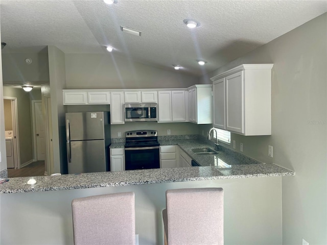 928 Nuthatch Ave, The Villages, FL 32163 - kitchen featuring stainless steel appliances, a textured ceiling, a sink, white cabinetry, and a peninsula