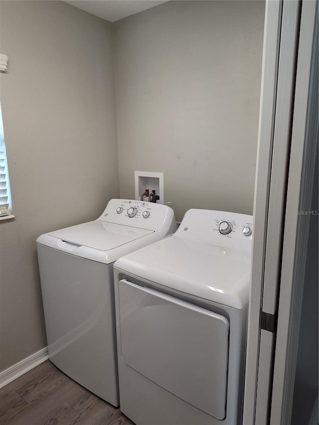928 Nuthatch Ave, The Villages, FL 32163 - laundry area featuring washing machine and clothes dryer, wood finished floors, and baseboards
