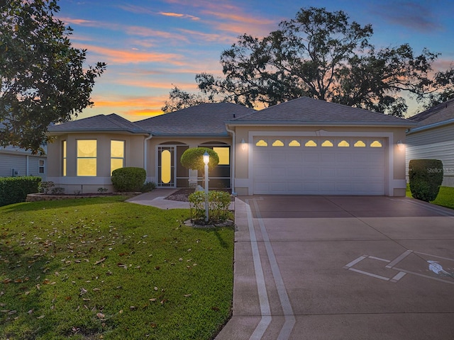 view of front of home featuring a garage and a yard