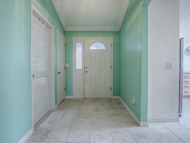 foyer with a textured ceiling, light tile patterned floors, and crown molding