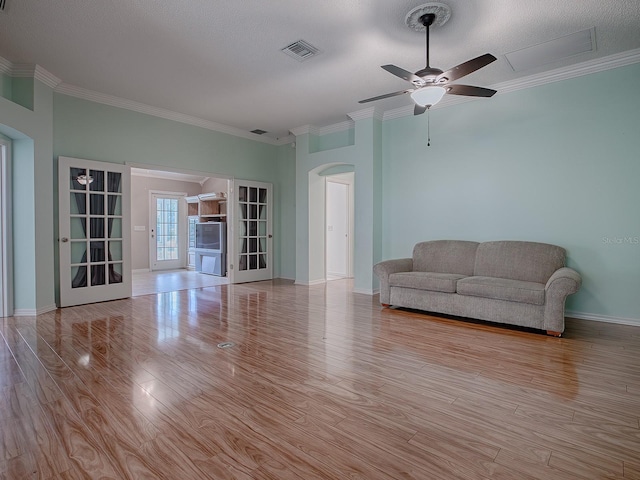 unfurnished living room with ceiling fan, a textured ceiling, crown molding, and light hardwood / wood-style flooring