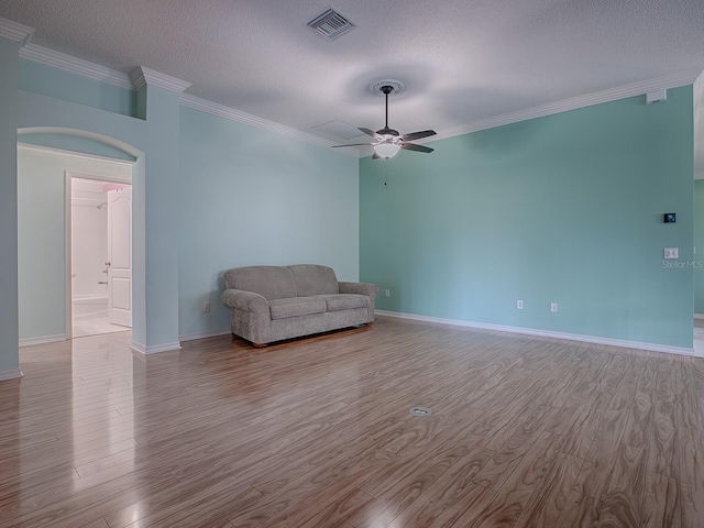 unfurnished room featuring ceiling fan, a textured ceiling, light wood-type flooring, and ornamental molding