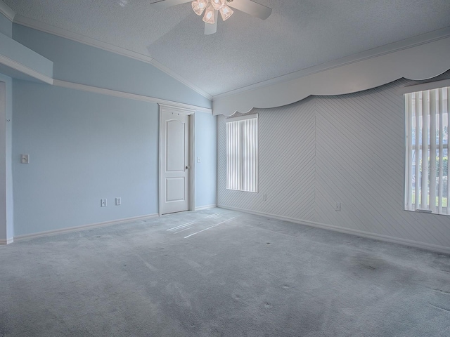 carpeted empty room with lofted ceiling, a textured ceiling, and ceiling fan