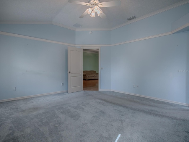 carpeted spare room with ornamental molding, ceiling fan, and vaulted ceiling