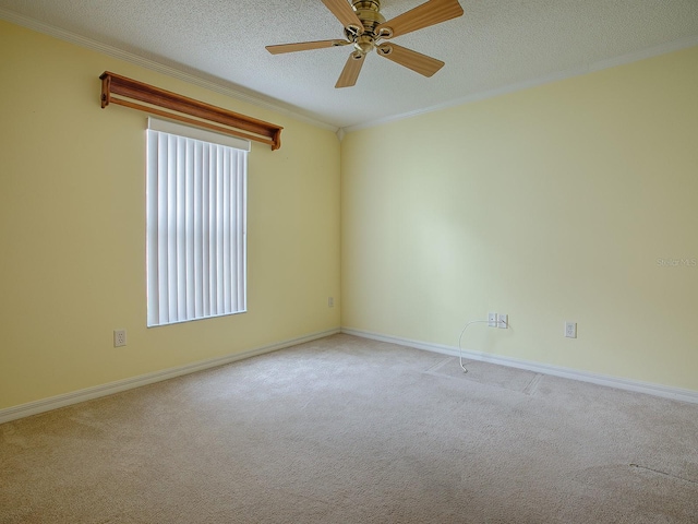 unfurnished room with ceiling fan, light colored carpet, a textured ceiling, and ornamental molding