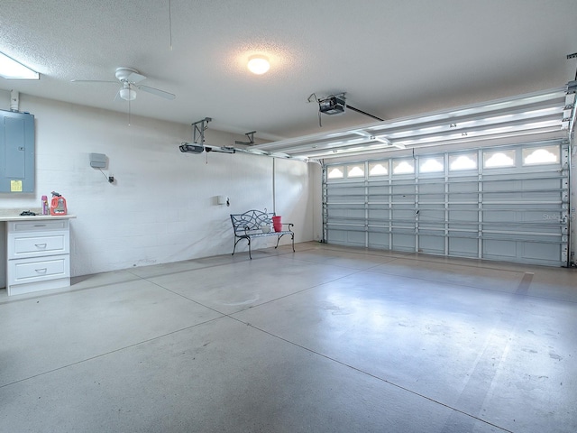 garage featuring a garage door opener, electric panel, and ceiling fan