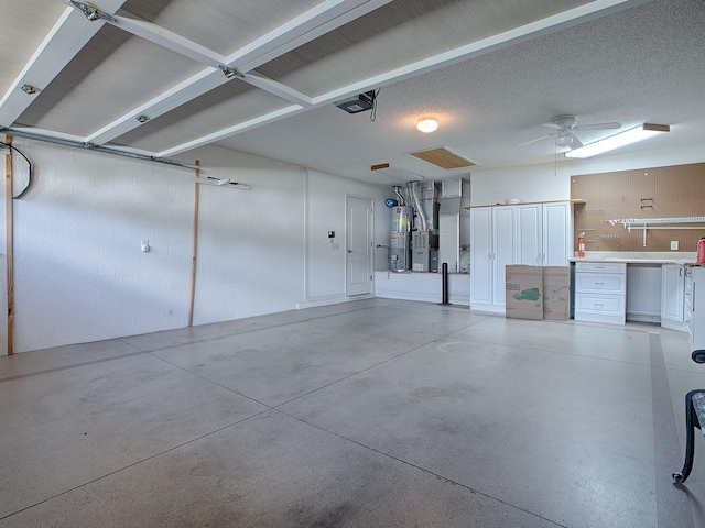 garage with a garage door opener, gas water heater, and ceiling fan