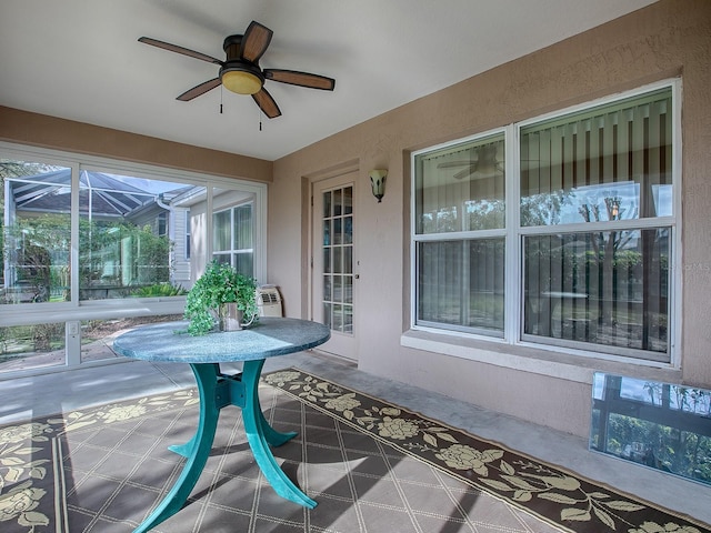 unfurnished sunroom featuring ceiling fan