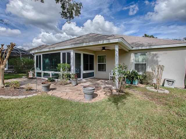 back of property featuring ceiling fan, a yard, a lanai, and a patio area