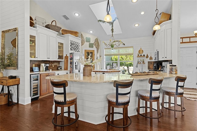 kitchen featuring white cabinets, wine cooler, pendant lighting, and appliances with stainless steel finishes