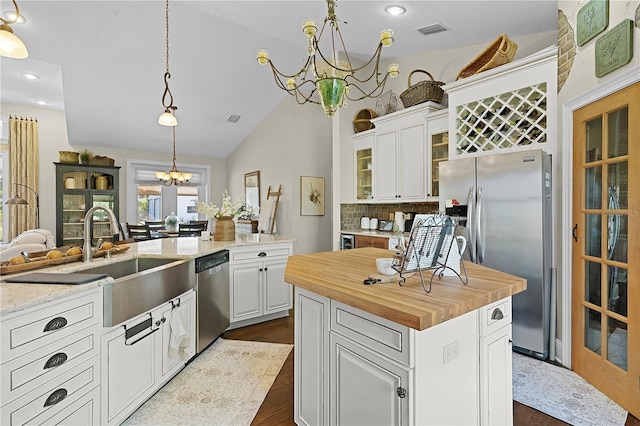 kitchen featuring stainless steel appliances, a chandelier, white cabinets, and a kitchen island