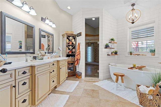 bathroom with wood walls, a tub to relax in, an inviting chandelier, vanity, and vaulted ceiling