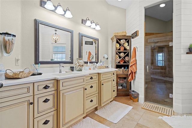 bathroom featuring tile patterned flooring, an enclosed shower, and vanity