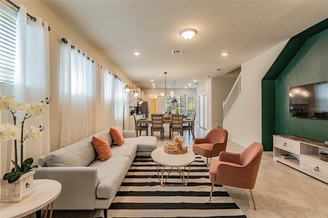 living room with a textured ceiling, a healthy amount of sunlight, and light tile patterned flooring