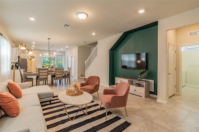 living room featuring a notable chandelier and a textured ceiling