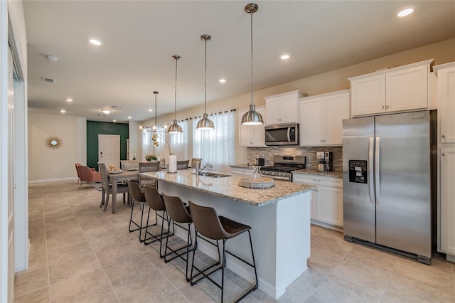 kitchen with white cabinetry, appliances with stainless steel finishes, and a center island with sink